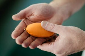 Hands holding a stress pendant