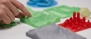 Finger touching 3D printed mountain