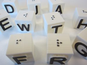 Dice with letters and braile on their surfaces