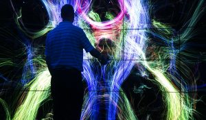 Person silhouetted standing in front of CAVE2 Immersive Virtual Reality System