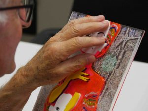 Close up of a person's hand exploring a tactile artwork