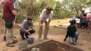 People looking into archeological dig pit