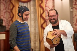 Researcher shows dodecahedron to man wearing EEG