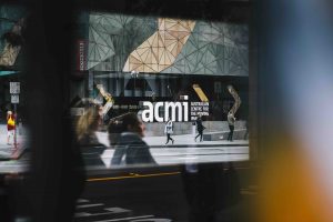 The ACMI sign viewed through a tram window